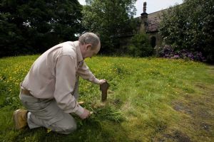 Derek Hutchinson, (pictured) unearths one of the grave markers found just below the surface, June 2008